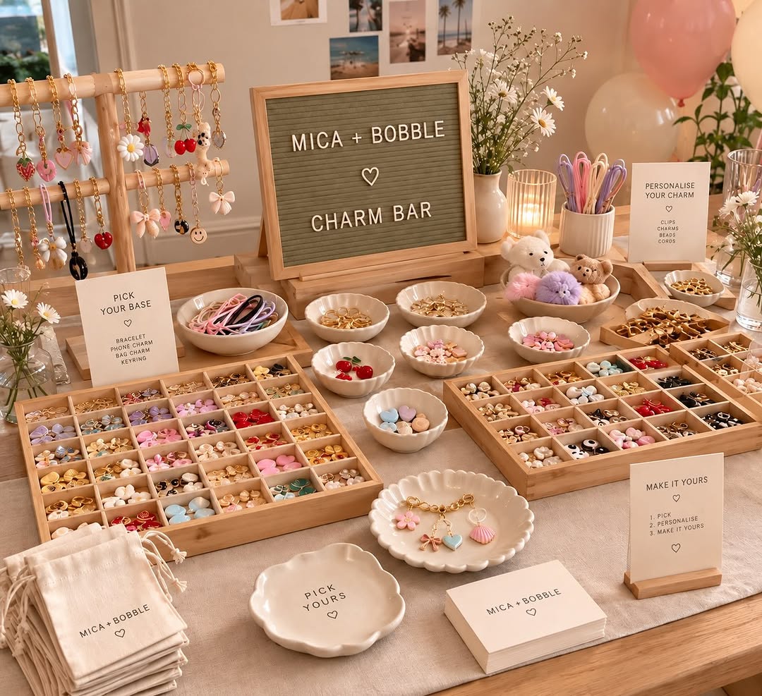 mica + bobble charm bar set up with trays of charms and a letter board