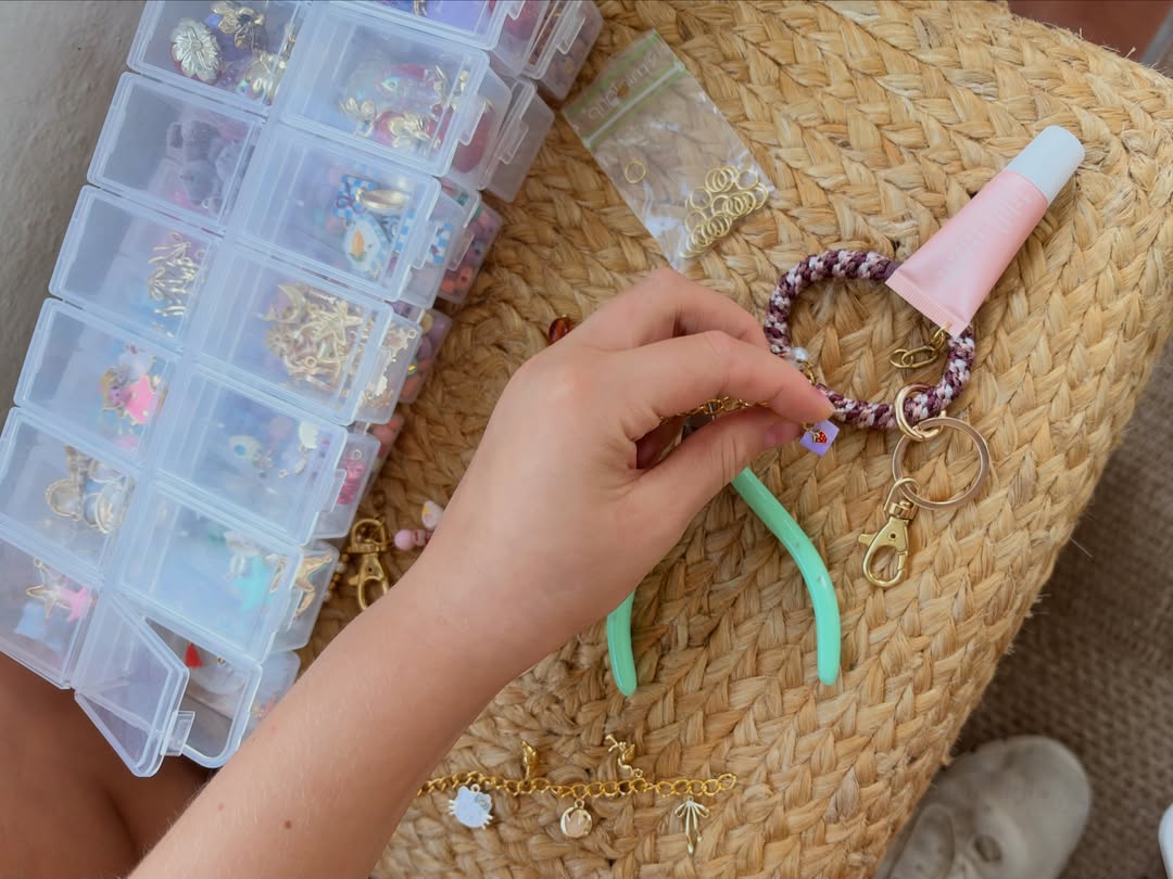 Hands making a charm bracelet